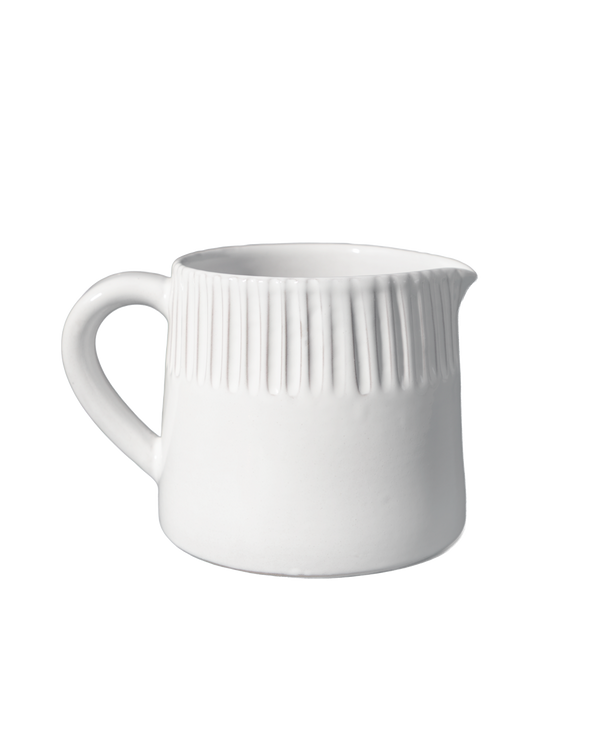 White ceramic pitcher with ribbed design on a white background