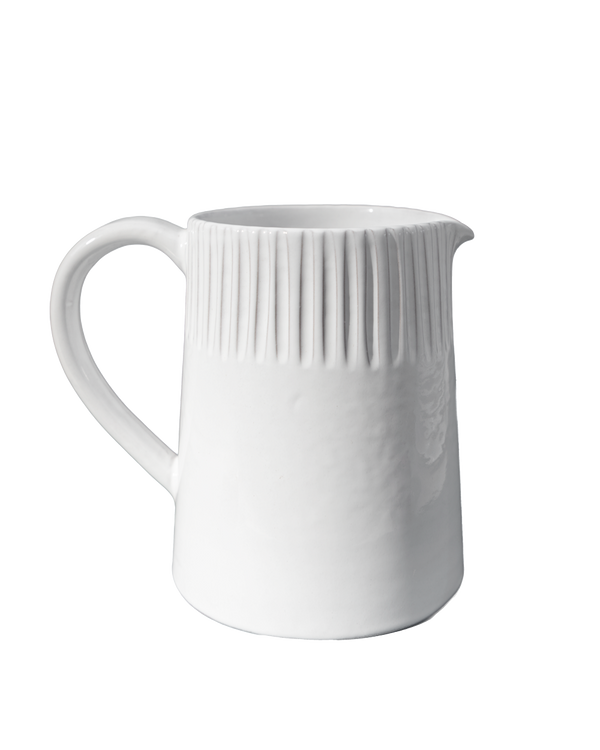 White ceramic pitcher with ribbed design on a white background