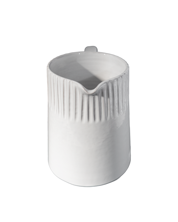 White ceramic pitcher with ribbed design on a white background