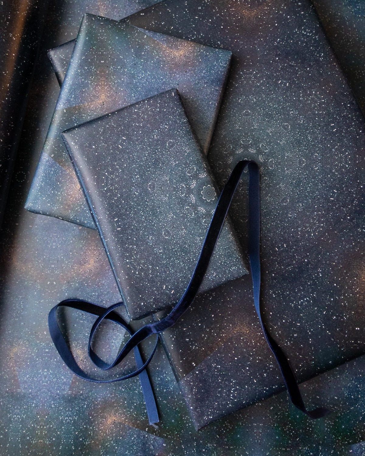 Gift boxes with a starry design and black ribbon on a matching background