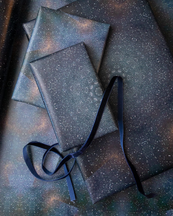 Gift boxes with a starry design and black ribbon on a matching background